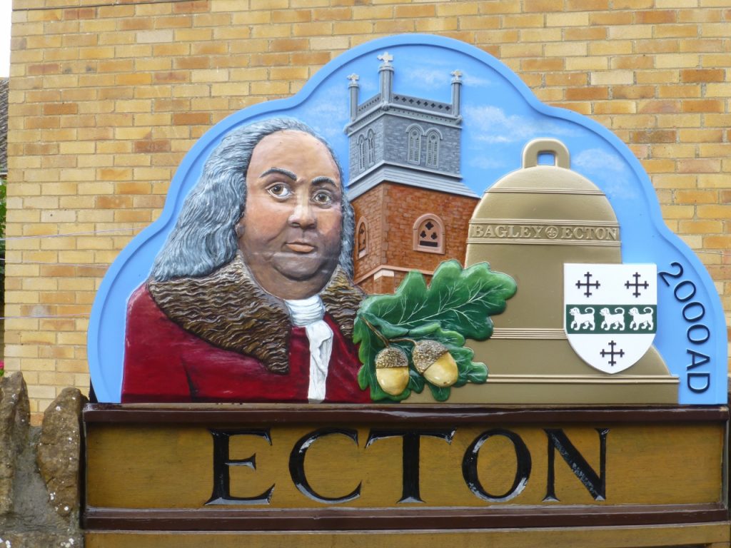 Ecton village sign featuring Benjamin Franklin, the church and local emblems